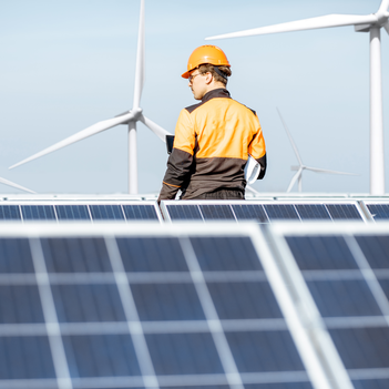 Ein Ingenieur in gelb-schwarzer Arbeitsschutzkleidung bei der Wartung von Solarmodulen mit digitalem Tablet auf einer Photovoltaik-Aufdachanlage. Er überwacht die Anlagen, um sicherzustellen, dass sie einwandfrei funktionieren. | © Getty Images