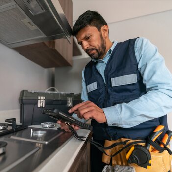 Supervisor, der eine Gasinspektion in einem Haus durchführt und auf einem Klemmbrett Notizen macht. | © iStock